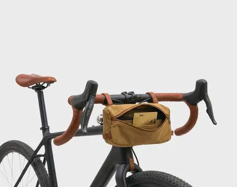 Guldfarvet Ondrela-kort i en styrtaske på en cykel